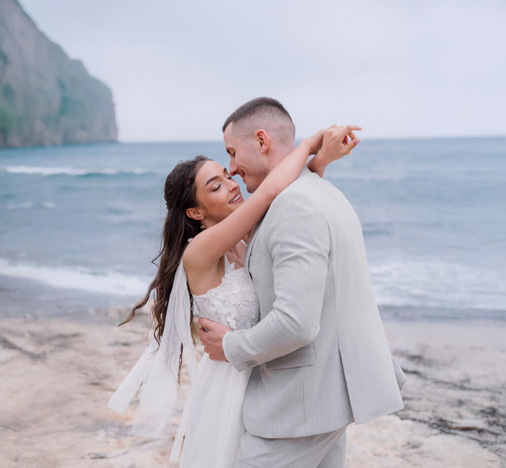 Romantischer Heiratsantrag am Strand mit Umarmung am Meer als Idee für einen persönlichen Antrag im Urlaub